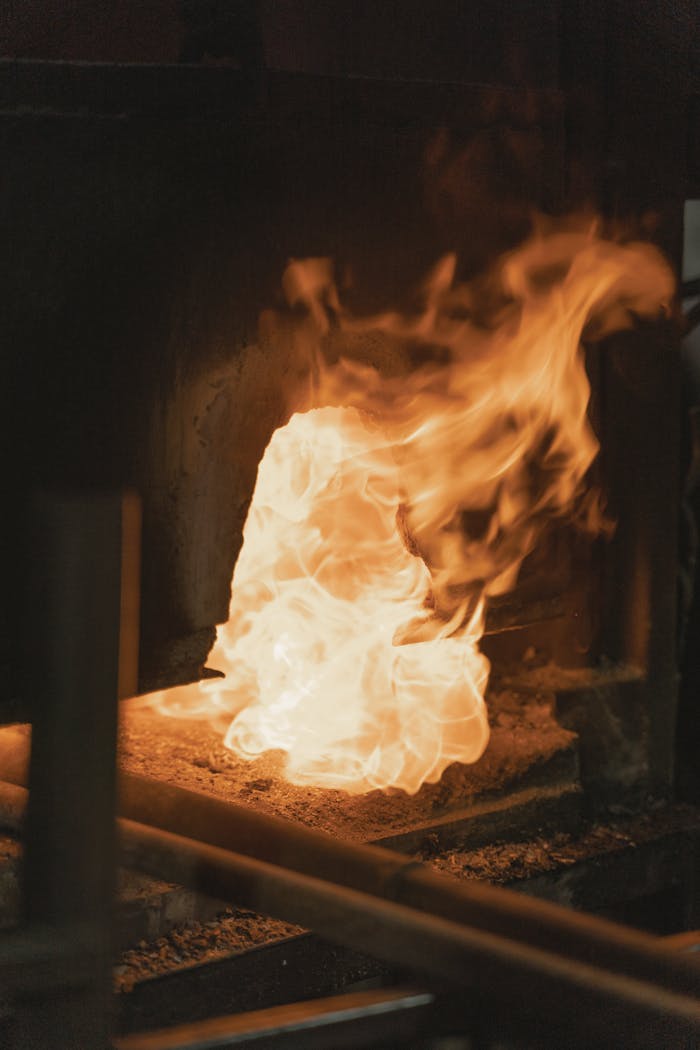 Close-up of a bright flame in a traditional blacksmith's forge, showcasing intense heat.